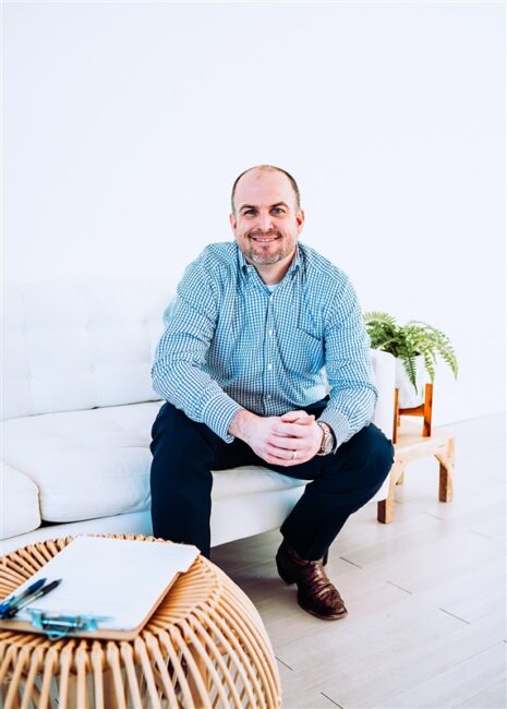Rane Wallace sitting on a couch at Fort Wellness Counseling in Fort Worth